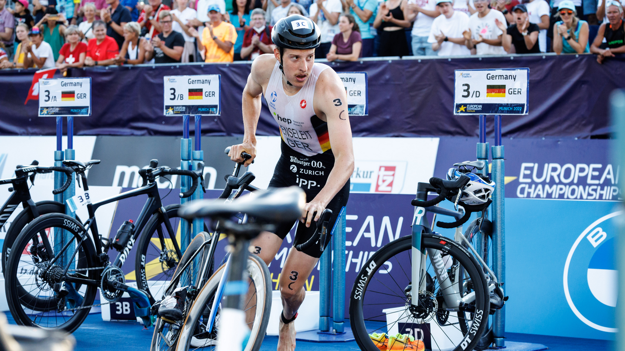 Ein deutscher Triathlet wechselt in der Wechselzone vom Schwimmen auf das Radfahren bei den European Championships 2022 in München.