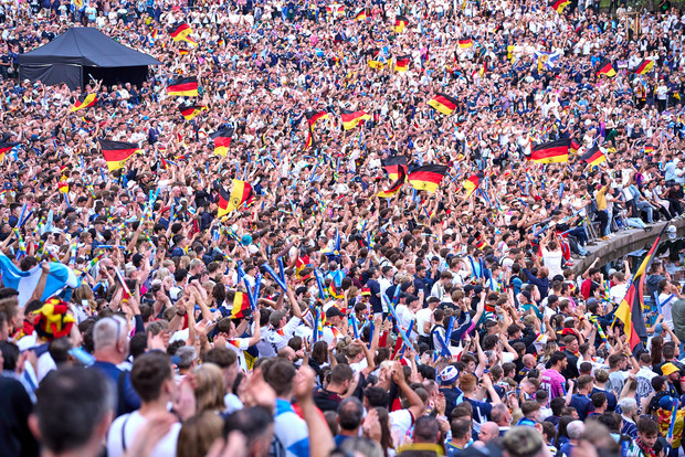 Große Menschenmenge jubelt mit vielen Deutschlandfahnen bei einem öffentlichen Sportereignis.