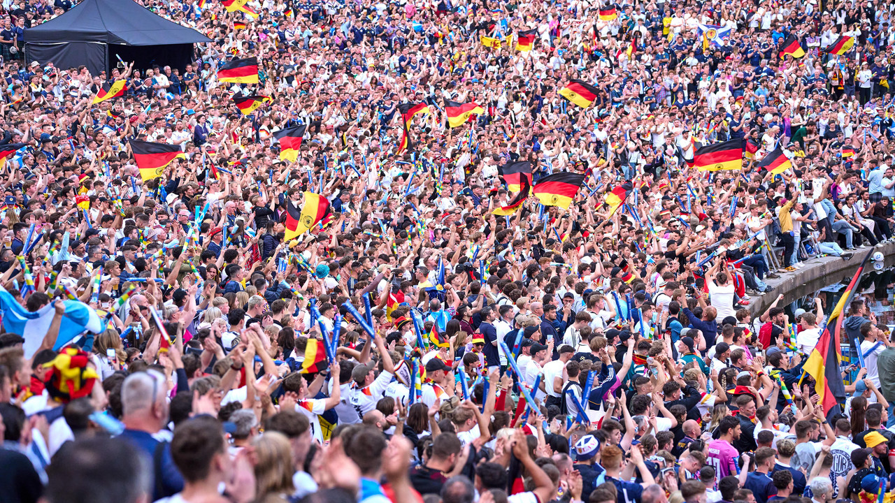 Große Menschenmenge jubelt mit vielen Deutschlandfahnen bei einem öffentlichen Sportereignis.