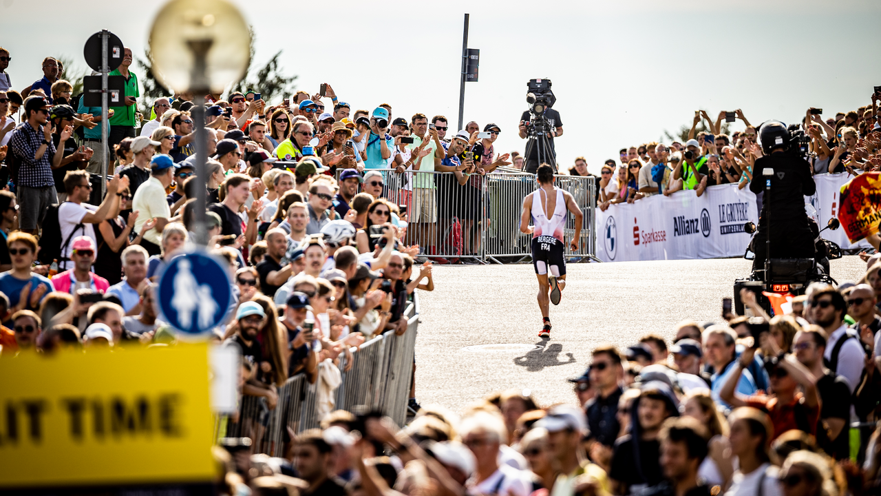 Triathlet beim Laufwettbewerb der European Championships 2022 in München, umgeben von jubelnden Zuschauern.