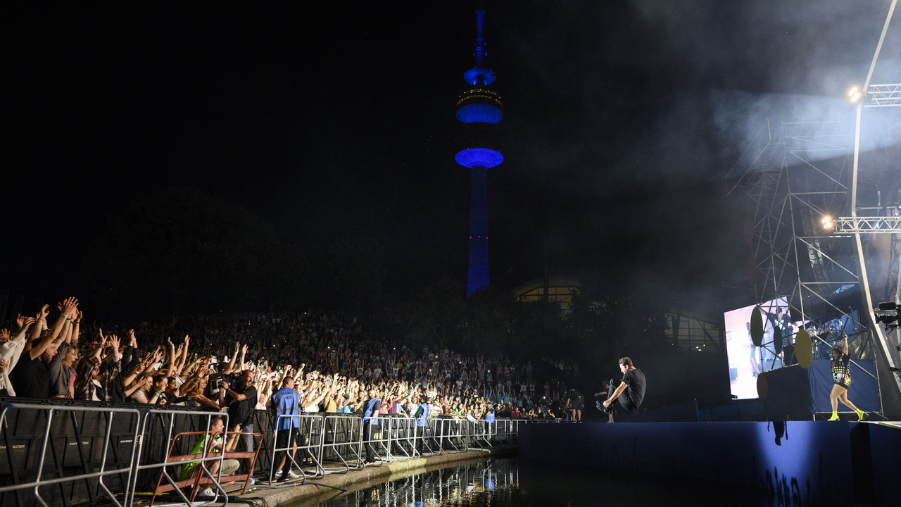Großes Konzert mit jubelnder Menge, beleuchtetem Fernsehturm und Bühne bei Nacht.